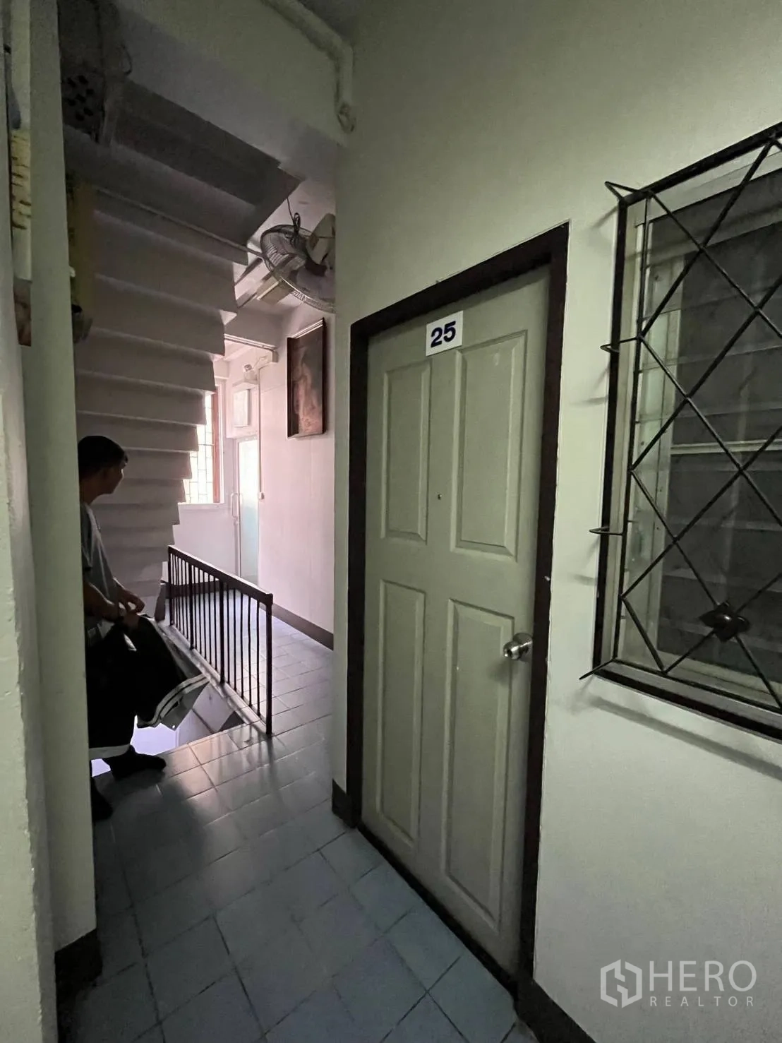 Shophouse for rent in Khlong Toei, Bangkok - Stairwell landing with a numbered room door and window leading to upper floors.