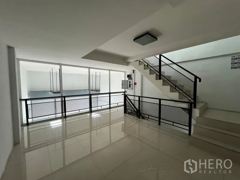 Warehouse for rent in Bang Phli, Samut Prakan - Upper landing with stairs and a glass wall looking into the double-height space.
