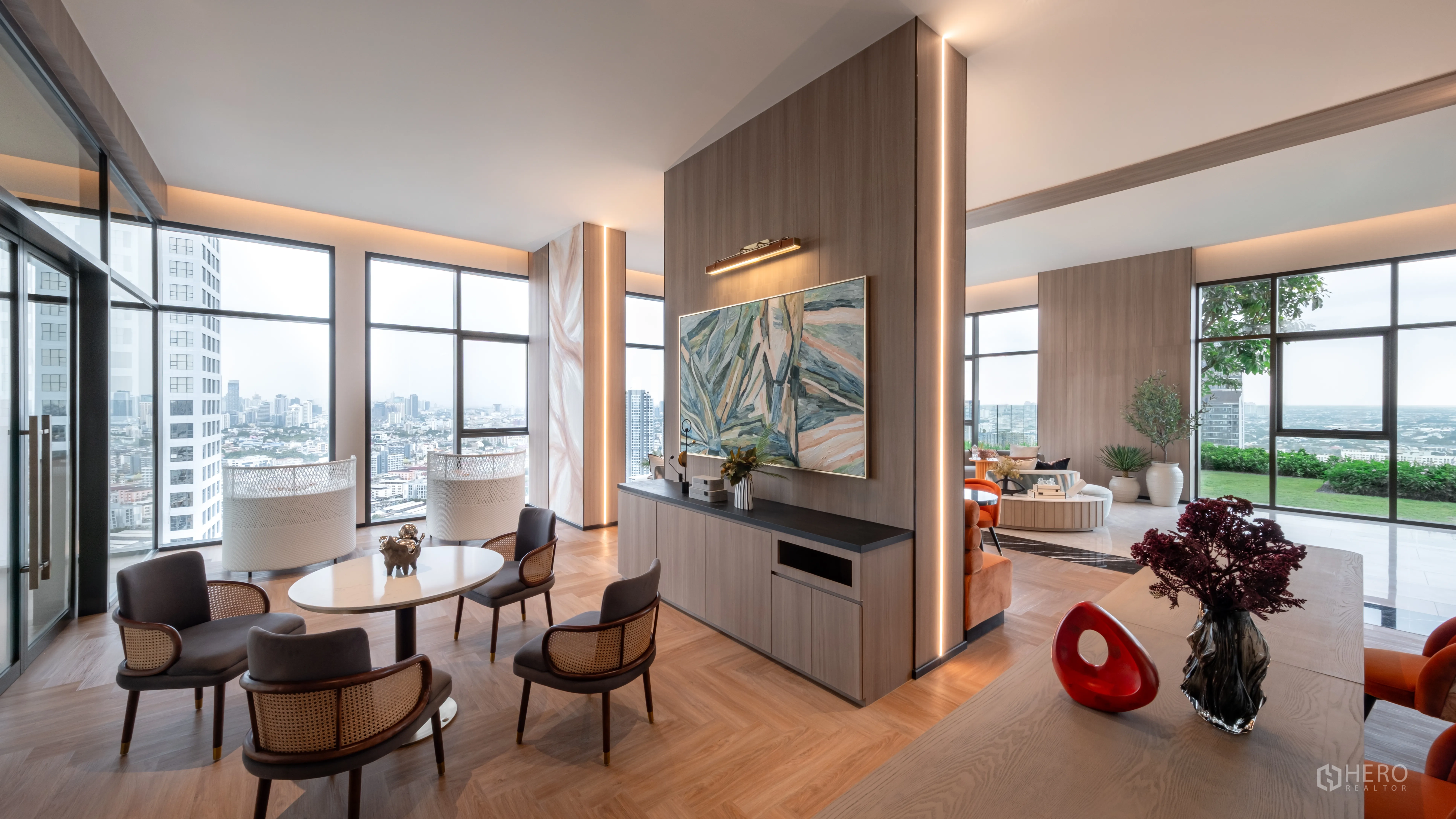 Condominium for sale in Khlong Toei, Bangkok - Modern lounge with floor-to-ceiling windows, city skyline views, multiple seating areas, and access to a terrace with greenery.