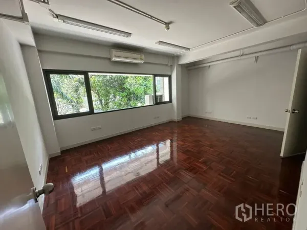 办公空间 出租 - 采光充足的办公房间，窗外绿意，亮面木地板。