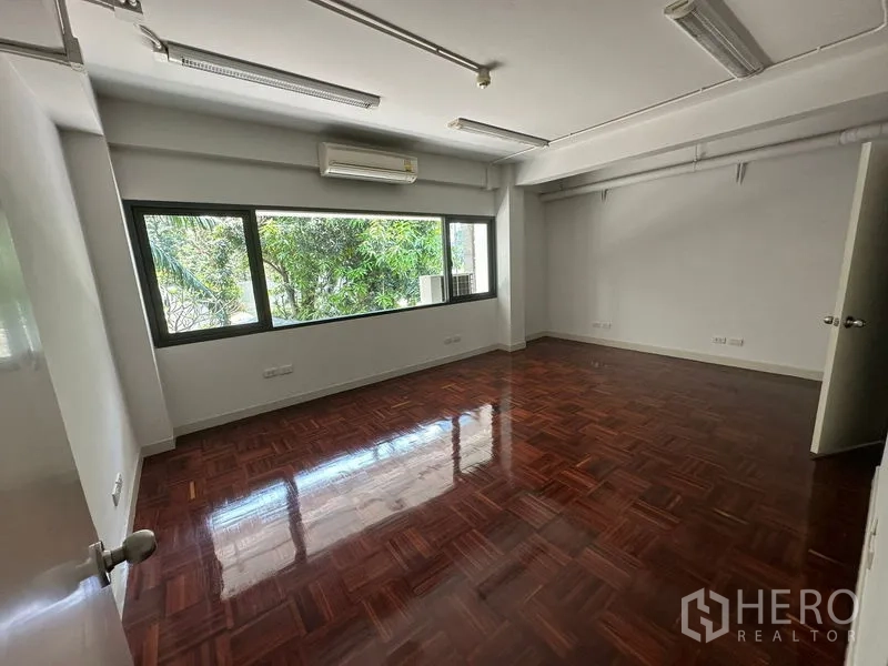 办公空间 出租 - 采光充足的办公房间，窗外绿意，亮面木地板。