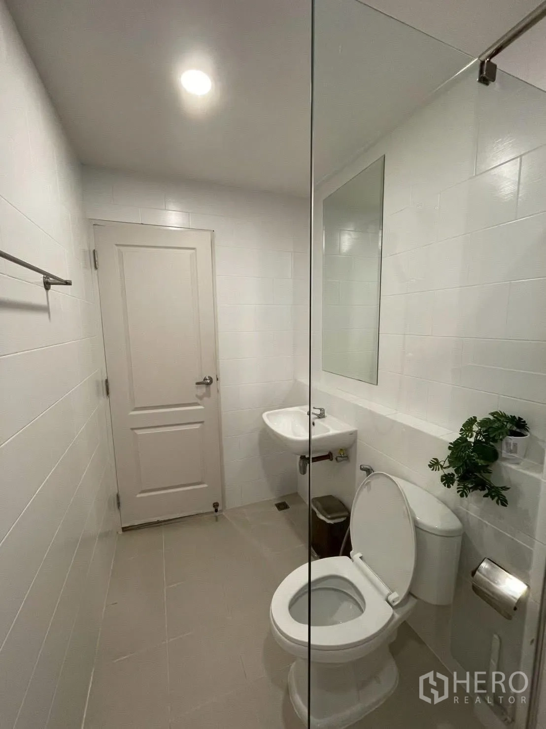 Detached House for rent in Prawet, Bangkok - Simple bathroom with white tiles, toilet, sink and towel rail.