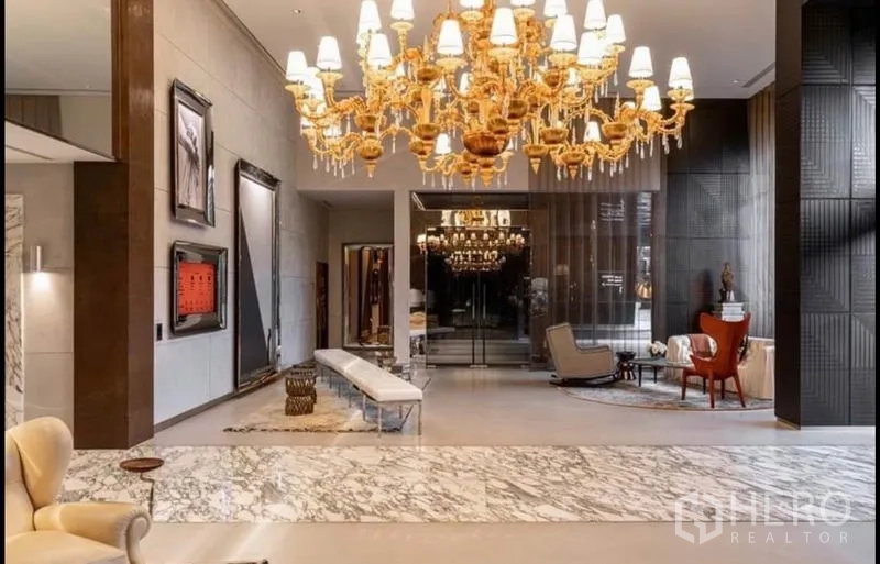 公寓 出租或出售在Watthana, Bangkok - 大堂，大理石地面与金色水晶吊灯及休息区。
