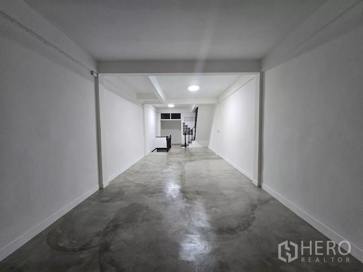 店屋 出租在Watthana, Bangkok - 上层抛光混凝土地面、白墙与中央楼梯口