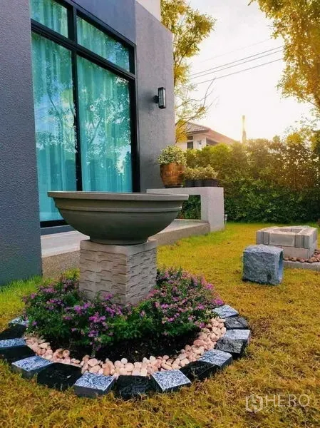 Detached House for rent in Bang Bo, Samut Prakan - Small landscaped garden with decorative stone planter beside floor-to-ceiling window.
