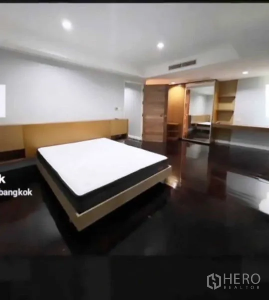 ทาวน์เฮาส์ ขายในKhlong Toei, Bangkok - ห้องนอนกว้าง พื้นไม้สีเข้ม ไฟดาวน์ไลท์ และตู้เสื้อผ้าบิวท์อิน