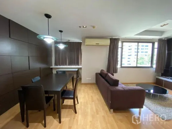 คอนโด ให้เช่าในKhlong Toei, Bangkok - พื้นที่นั่งเล่นและทานอาหารแบบเปิดโล่ง ปูพื้นไม้ โคมไฟแขวน และหน้าต่างบานใหญ่