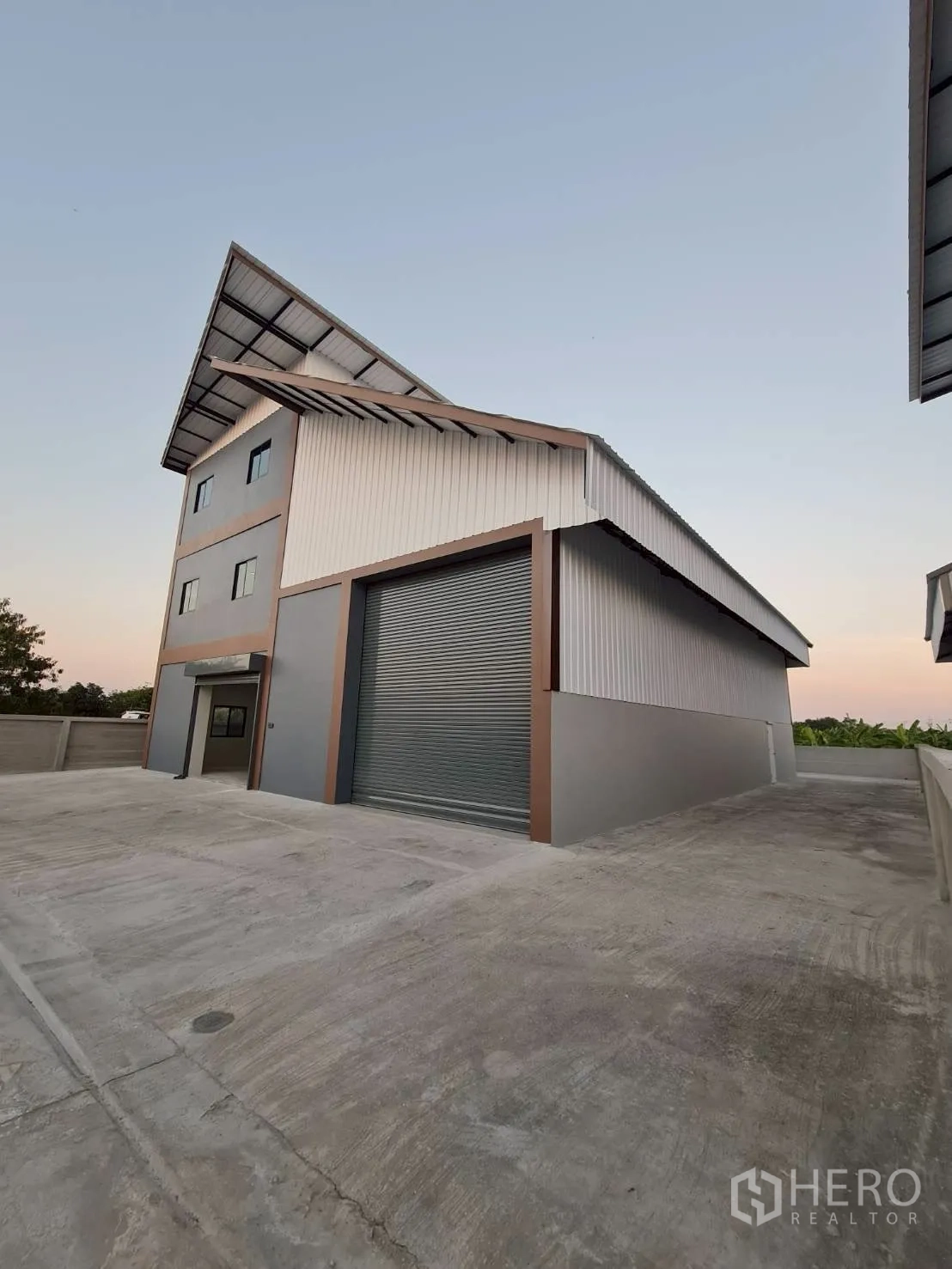 仓库 for rent in Mueang Nonthaburi, Nonthaburi - 仓库外观，卷帘门关闭并带宽阔混凝土外场。