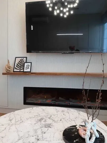 คอนโด ให้เช่าในRatchathewi, Bangkok - มุมนั่งเล่นทันสมัย ทีวีติดผนัง ชั้นลอยตกแต่ง เตาผิงไฟฟ้า และโต๊ะกลางหินอ่อนทรงกลม