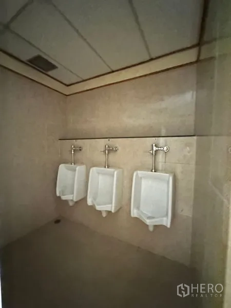 办公空间 出租在Pathum Wan, Bangkok - 男厕设三个挂墙式小便斗与瓷砖墙面。