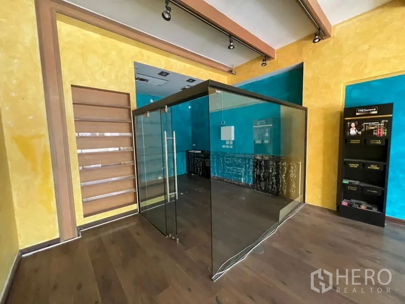 零售空间 出租在Watthana, Bangkok - 店中央玻璃房，可作收银/咨询间，配层架与展示架。