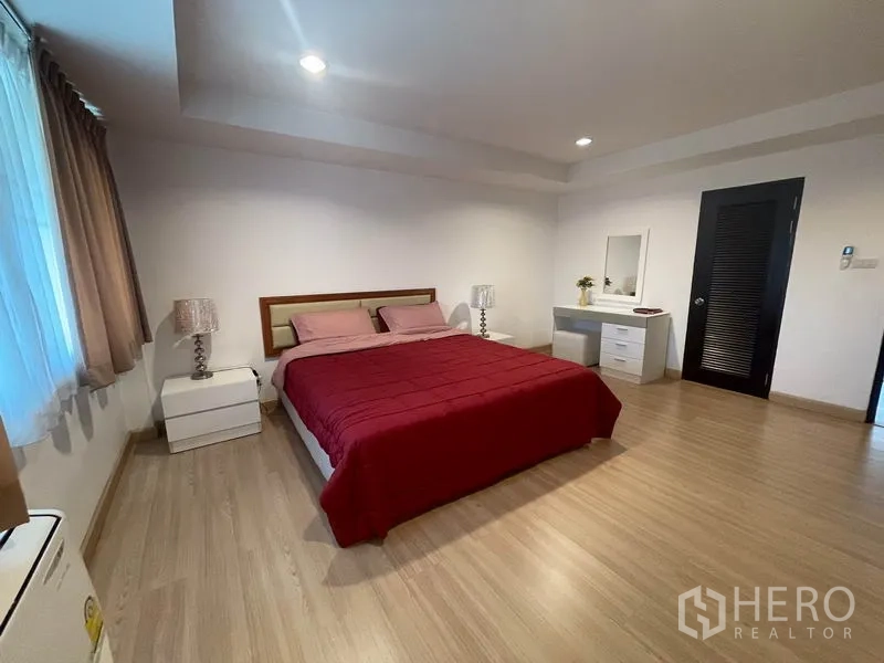 อพาร์ทเมนท์ ให้เช่าในKhlong Toei, Bangkok - ห้องนอนมาสเตอร์กว้าง เตียงคิงไซส์ โต๊ะหัวเตียง และโต๊ะเครื่องแป้ง พื้นไม้