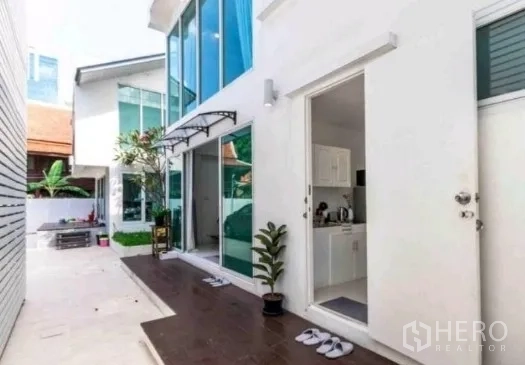 ทาวน์เฮาส์ ให้เช่าในKhlong Toei, Bangkok - ทางเดินข้างบ้าน ประตูกระจกบานเลื่อน เห็นครัวขนาดกะทัดรัดภายใน