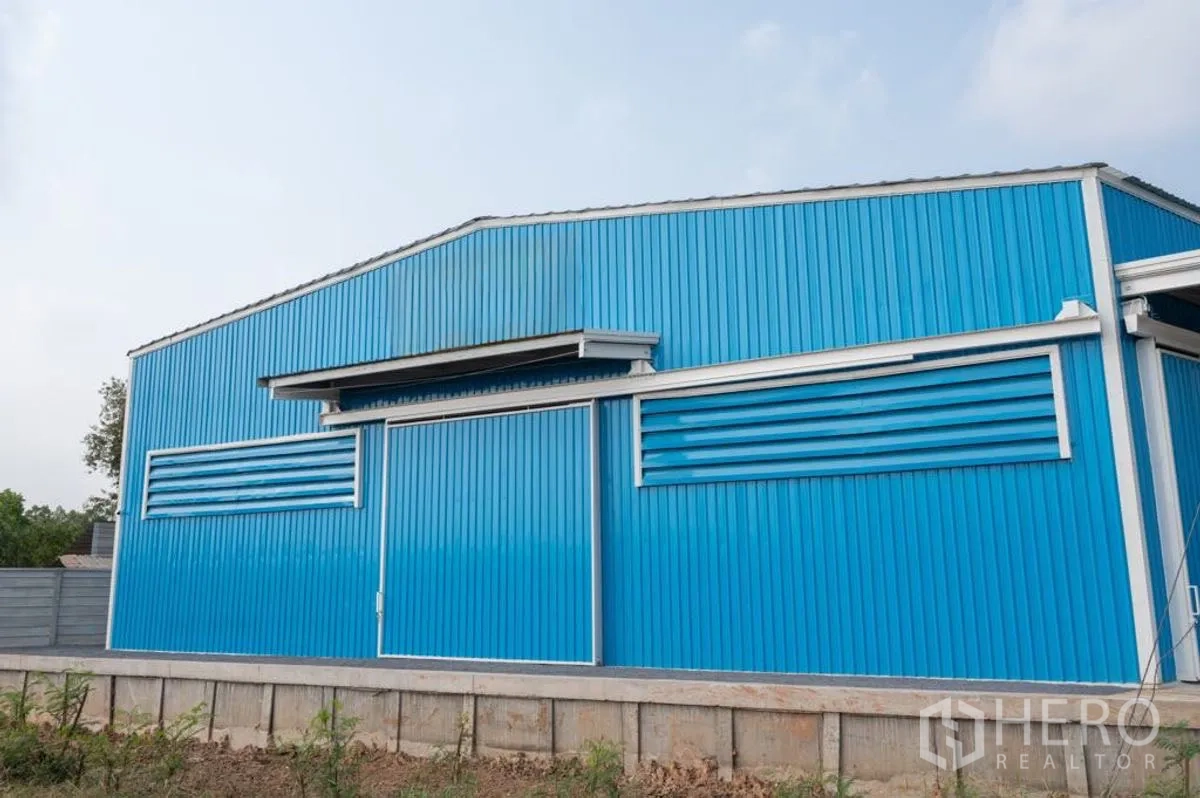 货栈 出租在Khlong Luang, Pathum Thani - 蓝色金属外墙仓库外观，配大滑动门和通风百叶。