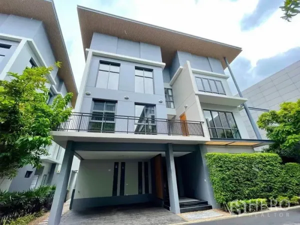 Detached House for rent in Bang Na, Bangkok - Modern three-storey detached house facade with large windows and a covered carport in Bang Na.