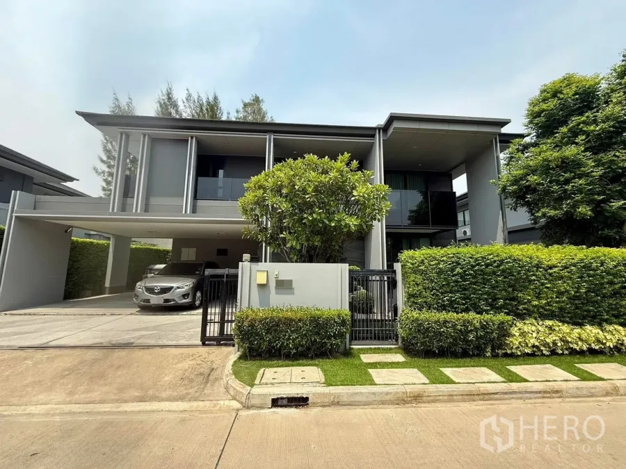 Detached House for rent in Bang Kapi, Bangkok - Modern two-storey detached house facade with gated entrance, hedge and covered three-car carport.