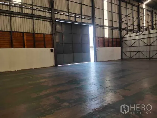 货栈 出租在Mueang Samut Sakhon, Samut Sakhon - 室内朝向超大滑动钢门的视角，卡车进出便捷