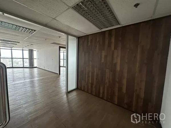Office Space for rent in Watthana, Bangkok - Bright corner of an open-plan office with wood-style flooring, a feature wood wall, glass partition, and floor-to-ceiling windows with city views.