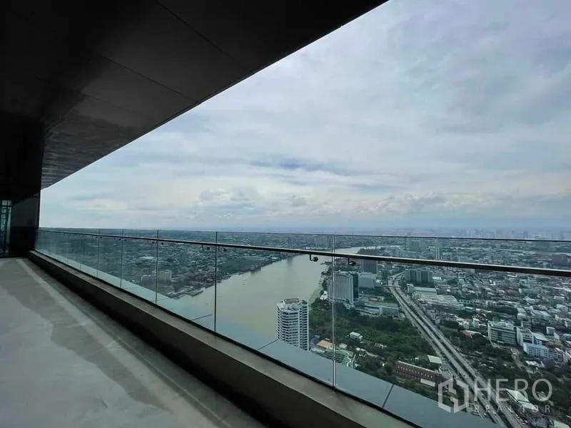 Condominium for sale in Bangkok - Long balcony with glass railing facing the Chao Phraya River and city skyline.