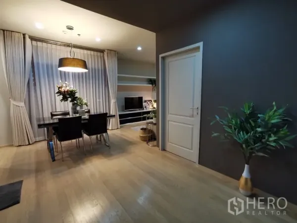 公寓 出售在Bangkok - 开放式客餐厅，木地板、落地窗帘与深色点缀墙面。