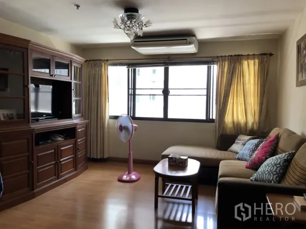 คอนโด ให้เช่าในPathum Wan, Bangkok - ห้องนั่งเล่นอบอุ่น โซฟาเข้ามุม ตู้ทีวีไม้ พื้นลามิเนต และหน้าต่างบานใหญ่