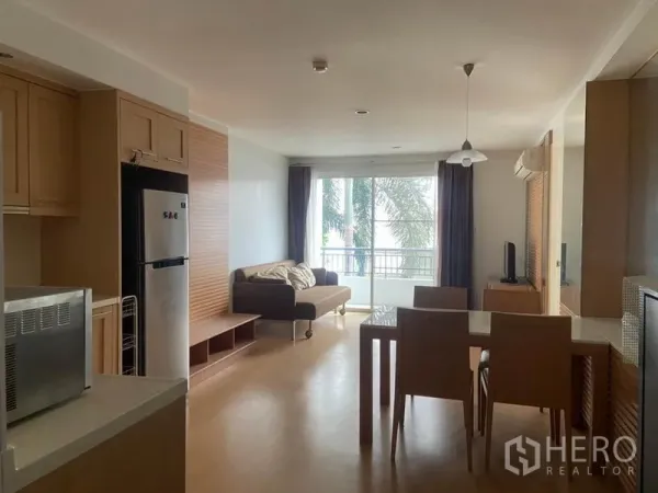 คอนโด ให้เช่าในWatthana, Bangkok - มุมมองจากครัวสู่พื้นที่นั่งเล่น เห็นโต๊ะอาหาร บานกระจกบานเลื่อน และวิวต้นไม้