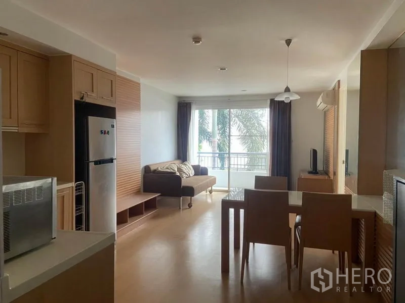 คอนโด ให้เช่าในWatthana, Bangkok - มุมมองจากครัวสู่พื้นที่นั่งเล่น เห็นโต๊ะอาหาร บานกระจกบานเลื่อน และวิวต้นไม้