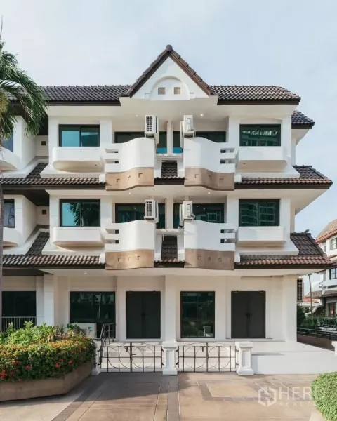 联排别墅 出租在Watthana, Bangkok - 曼谷瓦他那区三层现代联排别墅外立面，带阳台和瓦屋顶。