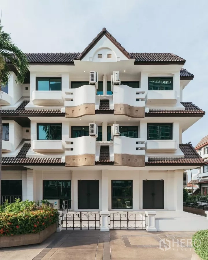 联排别墅 出租在Watthana, Bangkok - 曼谷瓦他那区三层现代联排别墅外立面，带阳台和瓦屋顶。