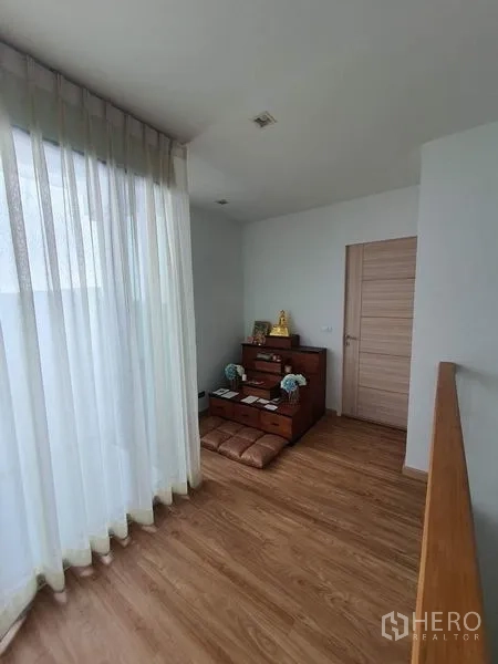 联排别墅 出售在Lat Phrao, Bangkok - 静谧角落，低矮桌与坐垫，靠落地窗。