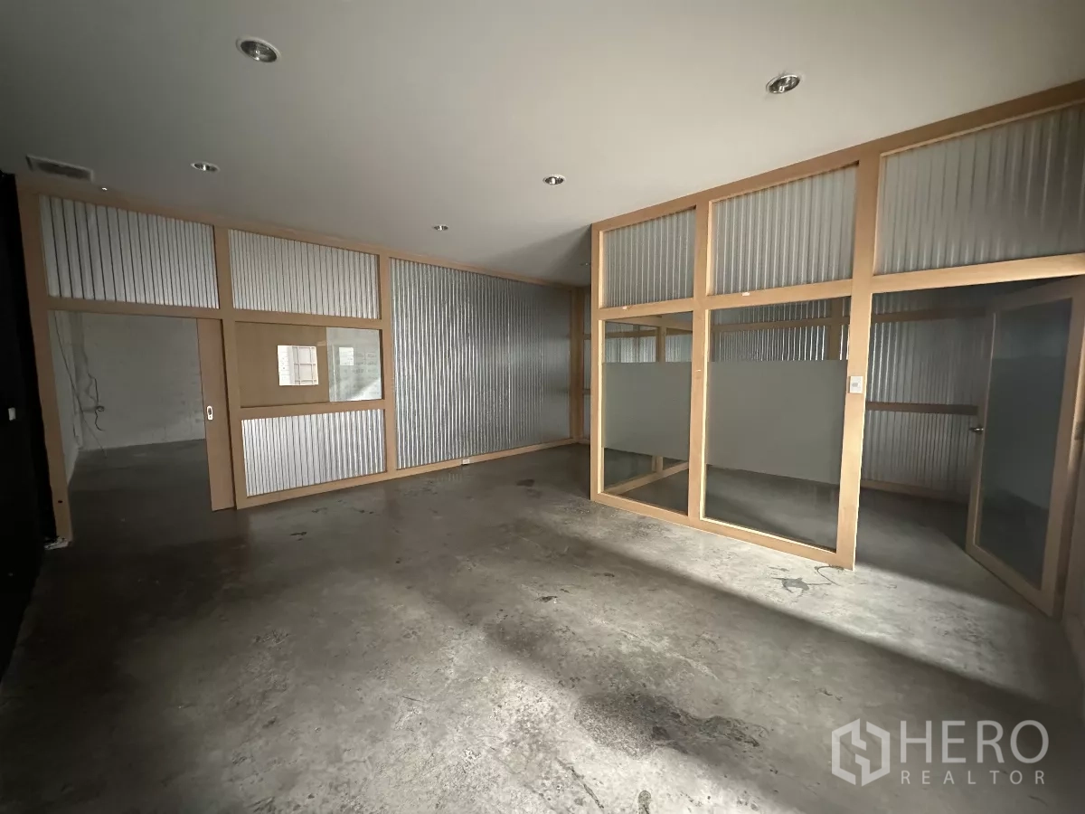 Warehouse for rent in Khlong Toei, Bangkok - Internal office suite with glass partitions and corrugated panels inside the warehouse.