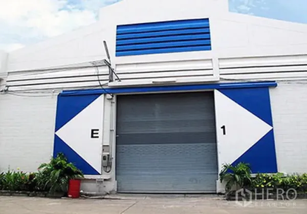 货栈 出租在Prawet, Bangkok - 工业仓库正立面，蓝白色装饰配大型卷闸门。