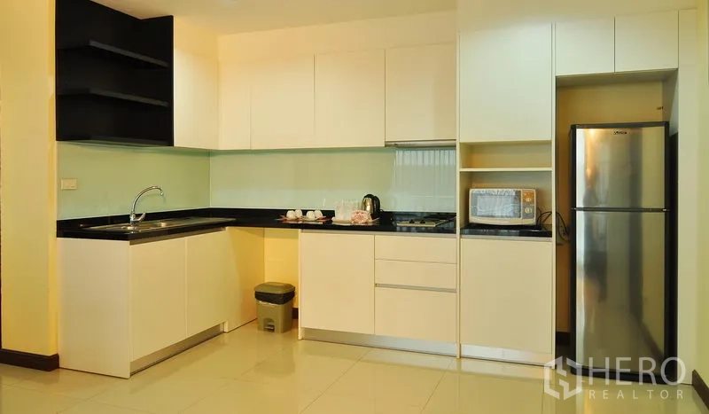 อพาร์ทเมนท์ ให้เช่าในKhlong Toei, Bangkok - ครัวบิวท์อิน ตู้สีขาว ท็อปหินสีดำ ตู้เย็น และไมโครเวฟ ในอพาร์ทเมนท์กรุงเทพฯ