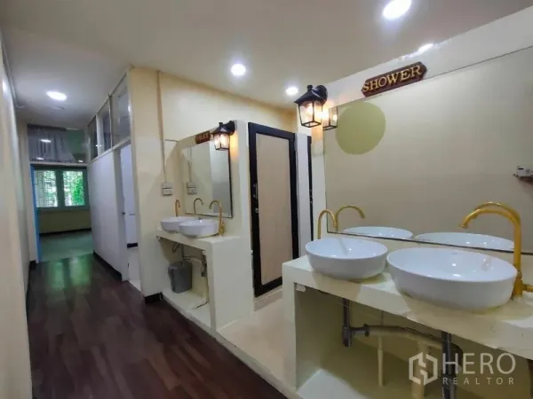 店屋 出租或出售在Bang Rak, Bangkok - 共享卫浴走廊，双台上盆，淋浴与厕间，暖色灯光。