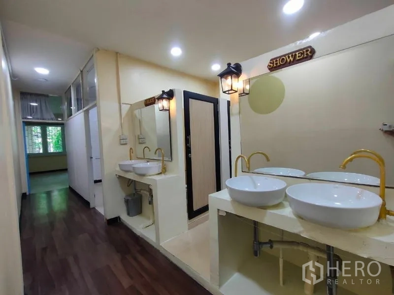 店屋 出租或出售在Bang Rak, Bangkok - 共享卫浴走廊，双台上盆，淋浴与厕间，暖色灯光。