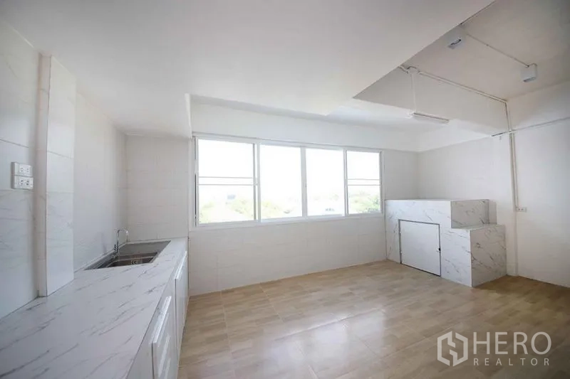 店屋 出租在Wang Thonglang, Bangkok - 简洁厨房，长台面与水槽，大窗引入自然光。