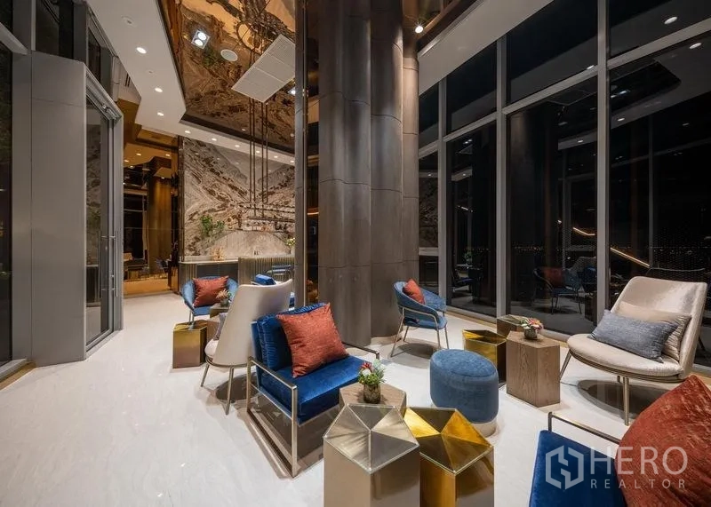 公寓 出售在Chatuchak, Bangkok - 挑高大堂，落地玻璃与舒适沙发的雅致会客区