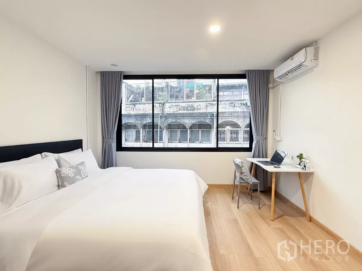 店屋 出租在Ratchathewi, Bangkok - 舒适大床房，木地板、大窗与学习角落，配空调。