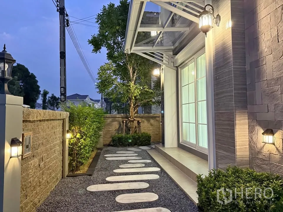 บ้านแฝด for rent in Mueang Samut Prakan, Samut Prakan - มุมสวนหน้าบ้านยามค่ำพร้อมไฟส่องสว่างและกันสาด