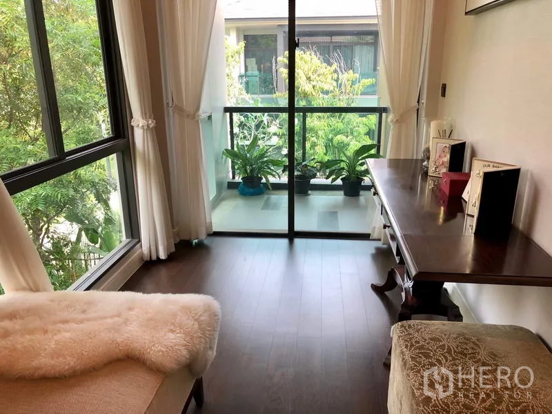 Detached House for rent or sale in Bang Kapi, Bangkok - Upstairs study nook with glass door to a small balcony overlooking trees.