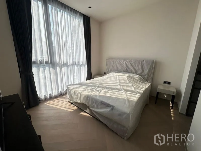 Condominium for rent - Minimalist bedroom with large windows flooding the room with natural light.