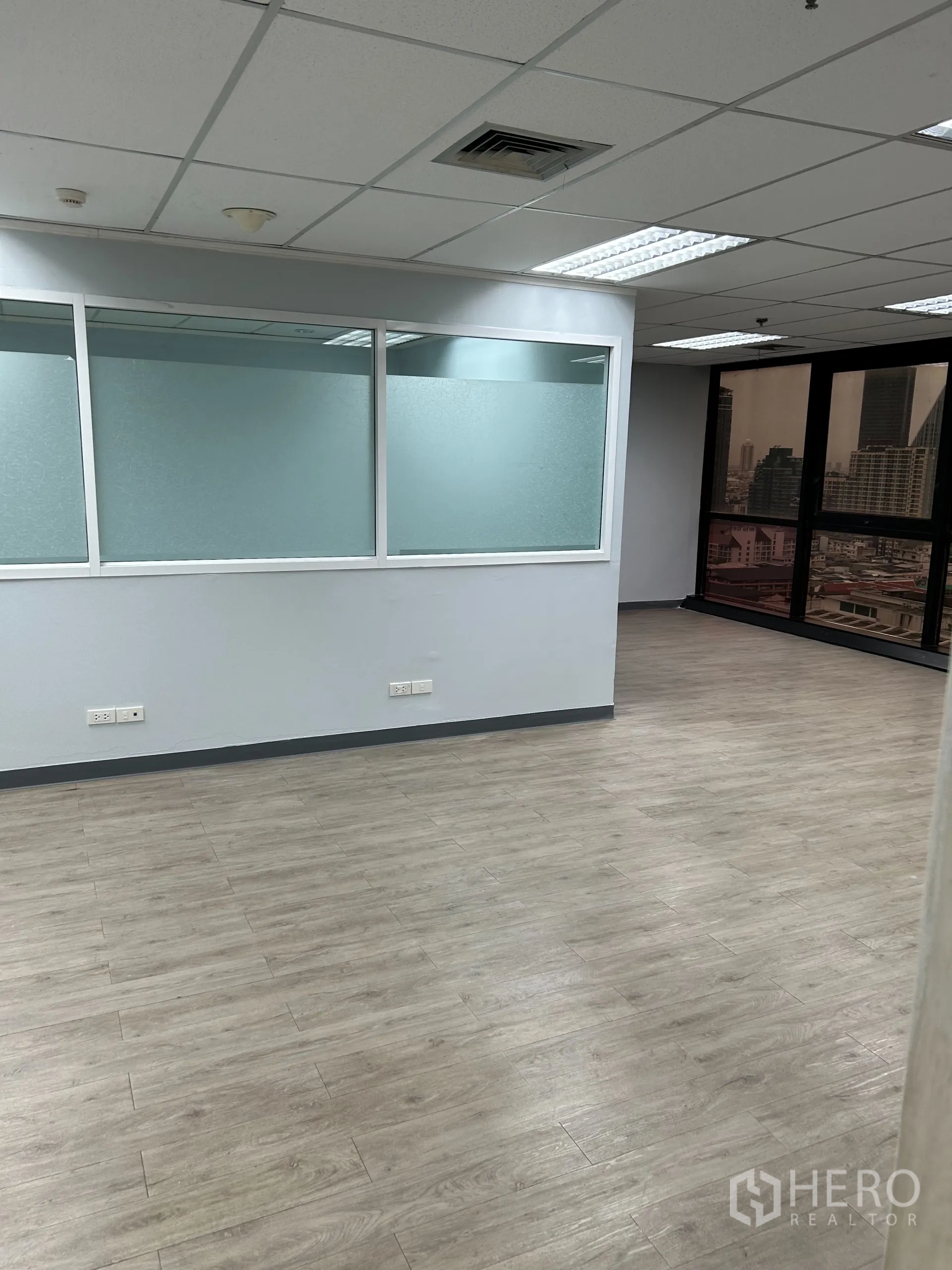 办公空间 出租在Khlong Toei, Bangkok - 开放工作区，磨砂玻璃隔断，木纹地板与外窗采光。