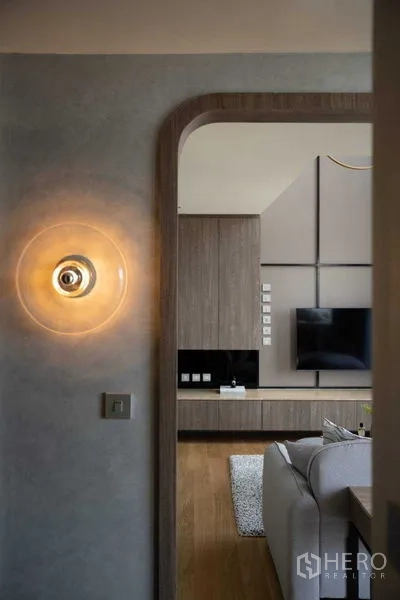 คอนโด ขายในKhlong Toei, Bangkok - ซุ้มทางเข้าพร้อมโคมไฟติดผนัง มองไปยังห้องนั่งเล่นโมเดิร์น พื้นไม้และตู้บิลต์อิน
