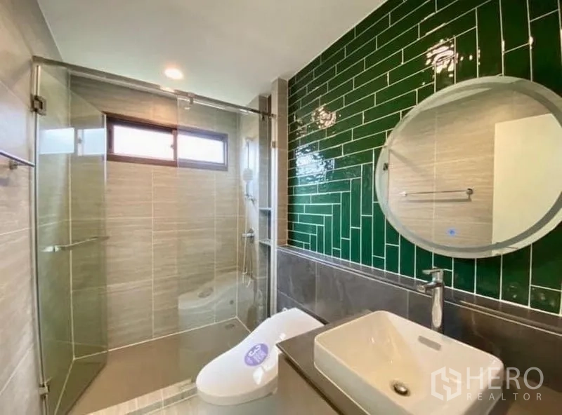 บ้าน ขายในBang Kapi, Bangkok - ห้องน้ำโมเดิร์น ผนังกระเบื้องสีเขียวและฉากกั้นอาบน้ำกระจก