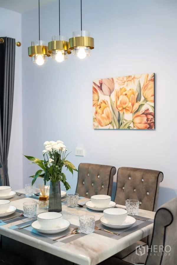 ทาวน์เฮาส์ ให้เช่า - โต๊ะอาหารหินอ่อน โคมไฟแขวนสีทอง และภาพดอกไม้ที่ผนัง