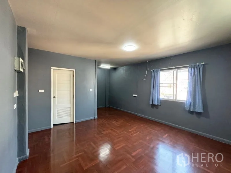 ทาวน์เฮาส์ ให้เช่าหรือขายในSuan Luang, Bangkok - ห้องโทนสีเทาพื้นไม้กว้างพร้อมหน้าต่างรับแสง