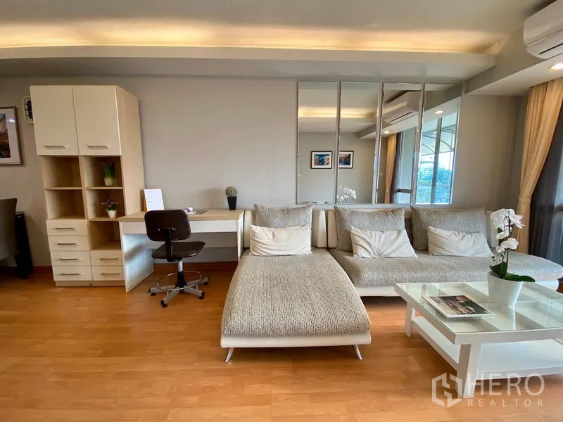 คอนโด ขายในKhlong Toei, Bangkok - ห้องนั่งเล่นพร้อมโซฟาตัวแอล ผนังกระจกเงา โต๊ะทำงานพร้อมชั้นวาง และไฟดาวน์ไลท์