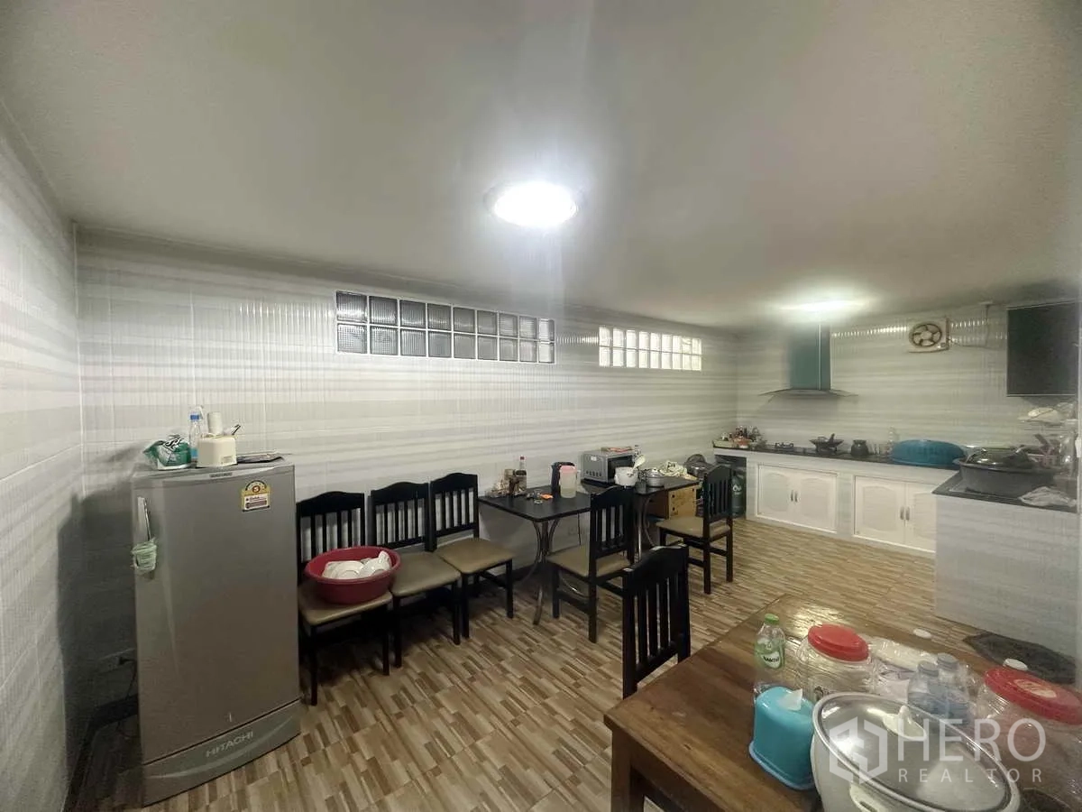 独立式住宅 出售在Pathum Thani - 宽敞泰式厨房，瓷砖墙面，燃气灶、抽油烟机和用餐区。