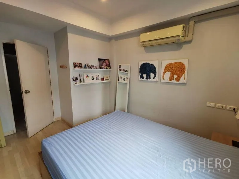 ทาวน์เฮาส์ ให้เช่าหรือขายในYan Nawa, Bangkok - ห้องนอนอบอุ่น ชั้นโชว์ผนัง รูปช้าง และเครื่องปรับอากาศ
