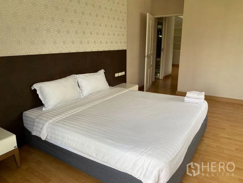 คอนโด ให้เช่าในKhlong Toei, Bangkok - มุมห้องนอนแสดงผนังตกแต่ง โต๊ะข้างเตียง และทางเข้าห้องรับแขก